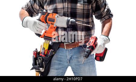 Carpenter worker at work holding the rechargeable hammer drill and the rechargeable screwdriver, isolated on white background. Construction industry. Stock Photo