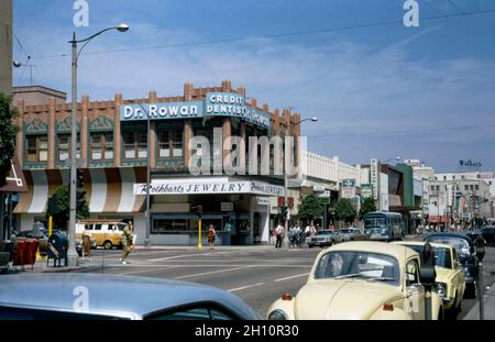 A view looking down Pine Avenue, Long Beach, California, USA in 1972. The city is located within the Los Angeles metropolitan area. This is one of the main shopping streets downtown. Many of the older buildings still remain, including the one on the corner housing a dental practice and jeweller’s shop. This image is from an old American amateur Kodak colour transparency – a vintage 1970s photograph.