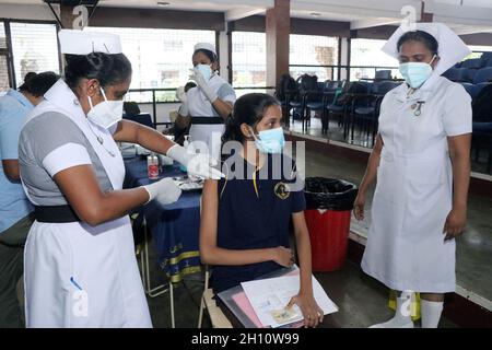 Colombo, Sri Lanka. 15th Oct, 2021. A student gets a vaccine against COVID-19 in Colombo, Sri Lanka, Oct. 15, 2021. Sri Lankan health authorities on Friday began administering the COVID-19 vaccines on school students between the ages of 18 and 19 with the Pfizer doses amidst a large-scale vaccination program ongoing in the country since January. Credit: Ajith Perera/Xinhua/Alamy Live News Stock Photo