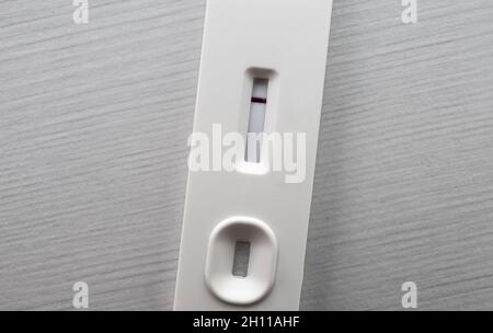 Testing with white generic home use slide test. Negative result with one red stripe. Covid-19 or pregnancy test concept. Copy space and room for text. Stock Photo
