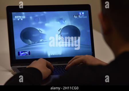 Beijing, China. 16th Oct, 2021. A man is seen watching a live TV broadcast of the launch of Shenzhou 13 spacecraft.At 0:23 Beijing time on October 16, 2021, China launched Shenzhou 13 manned spacecraft to the China space station. The spacecraft carried three astronauts, two men Zhai Zhigang and Ye Guangfu and one woman Wang Yaping. According to the plan, they will live on the Chinese space station for about six months. Credit: SOPA Images Limited/Alamy Live News Stock Photo