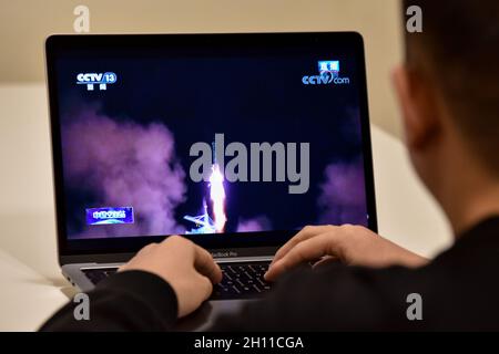 Beijing, China. 16th Oct, 2021. A man is seen watching a live TV broadcast of the launch of Shenzhou 13 spacecraft.At 0:23 Beijing time on October 16, 2021, China launched Shenzhou 13 manned spacecraft to the China space station. The spacecraft carried three astronauts, two men Zhai Zhigang and Ye Guangfu and one woman Wang Yaping. According to the plan, they will live on the Chinese space station for about six months. Credit: SOPA Images Limited/Alamy Live News Stock Photo