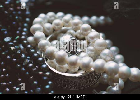 Skull surrounded by white and black pearls and jewellery Stock Photo