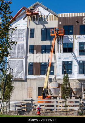 Workers on s cherry picker at a construction site Stock Photo