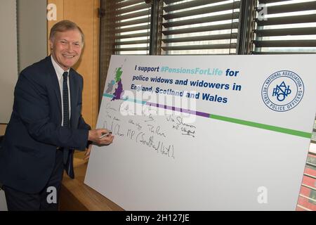 London, UK. 1st May, 2019. Sir David Amess MP for Southend West signs his support for the Pensions for Life for police widows and widowers in England, Scotland and Wales at a Parliamentary Drop-In at Portcullis House. Obituary: Sir David was tragically stabbed to death in his constituency on Friday 15th October 2021. Sir David had been an MP since 1983. Credit: Maureen McLean/Alamy