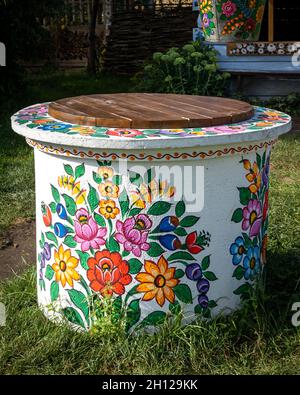 Zalipie, Poland - August 1, 2021: A white well painted in colorful floral pattern.  Sunny, summer day. Stock Photo