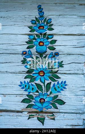 Zalipie, Poland - August 1, 2021: A colorful floral pattern, painted on a white wooden wall. Stock Photo