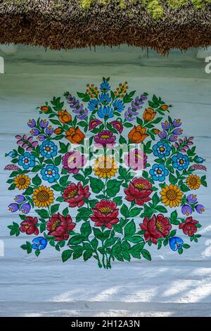 Zalipie, Poland - August 1, 2021: A colorful floral pattern, painted on a white wooden wall. Stock Photo