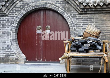 Maroon painted-round door-wooden cart-building materials. City Wall's Yongning South Gate-Xi'an-China-1588 Stock Photo