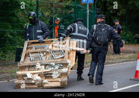 Aylesbury Vale, UK. On day six of the Anti HS2 protester eviction, National Eviction Team Enforcement Agent climbers were attempting to dismantle a huge protester tower built from pallets and scrap metal by the protesters. Dan Hooper nicknamed Swampy, is one of the activists in underground tunnels underneath the tower. HS2 were again causing huge traffic jams on the A413 due to their temporary traffic lights. The HS2 High Speed Rail construction work is destroying huge areas of woodland and wildlife habitats across the Chilterns. Credit: Maureen McLean/Alamy Live News Stock Photo