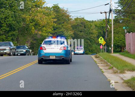 Woodbridge, Virginia, USA - October 15, 2021: Two Prince William County police cruisers speed through a neighborhood responding to a call for help. Stock Photo