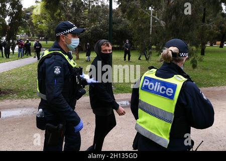 Melbourne, Australia, 16 October, 2021. Police lead a protester away during an attempt to hold a 'Stand Against Tyranny' rally put down by a massive police presence around the Carlton area. Melbourne reported less than 2000 new cases of COVID-19 for the first time in days and is slowly moves towards 80% vaccination and reopening. Credit: Michael Currie/Speed Media/Alamy Live News Stock Photo