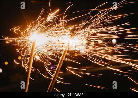 Bright glittering burning sparkler on dark background. Close up Stock Photo