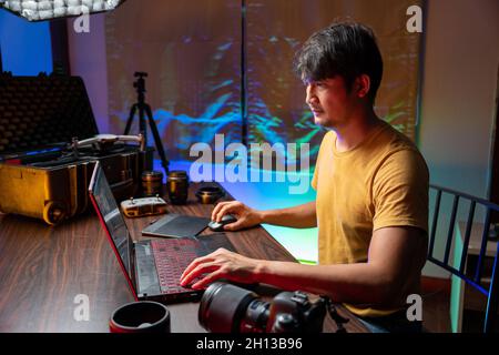 A man makes video editing. Video production. Color Correction. Sound editing. Film making. The work of a freelancer. Equipment filmmaking. Create vide Stock Photo