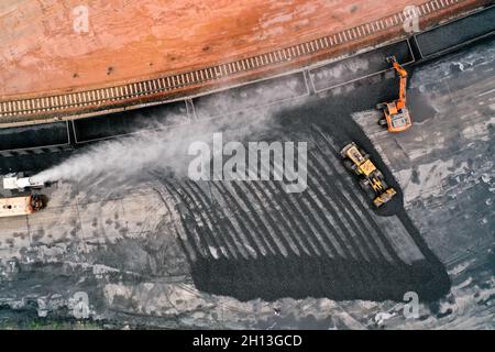 (211016) -- QIAN'AN, Oct. 16, 2021 (Xinhua) -- Aerial photo taken on Sept. 16, 2021 shows transport vehicles unloading coke from a train under dust control measures at a logistics yard in Qian'an Ctiy, north China's Hebei Province. Qian'an in Hebei Province is a major county in steelmaking industry in north China, with a large transportation demand for raw materials such as iron ore, coal and coke. In order to reduce pollution and traffic congestion caused by road transportation of bulk goods, special railway lines for key iron and steel enterprises have been built under a 'road-to-rail' Stock Photo