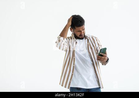 Indian man use phone confused isolated on white background Stock Photo