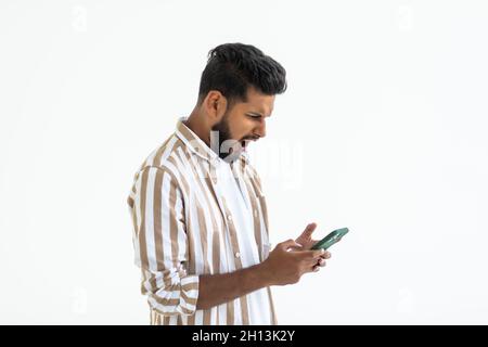 Image of excited young happy bearded man posing isolated on white background using mobile phone chatting. Stock Photo