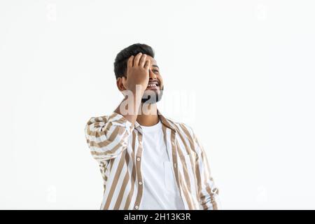 Young indian man wearing t-shirt standing over isolated white background suffering from headache desperate and stressed because pain and migraine. Han Stock Photo