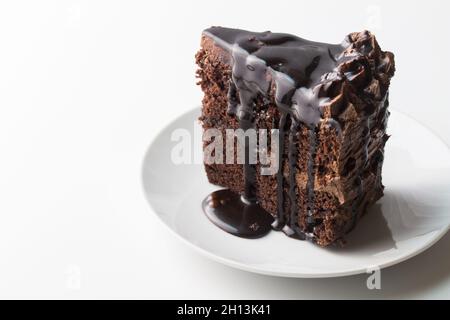Piece of chocolate cake with chocolate dripping sauce isolated on white with copy space Stock Photo