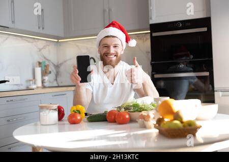 Man showing mobile phone and thumb up at table Stock Photo