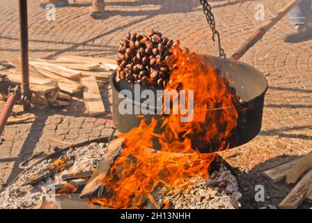 Roasted Chesnut, italian Caldarroste, jump on the flames at the Marrone Chestnut Fair in Cuneo, Piedmont, Italy Stock Photo