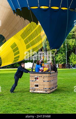 Vilnius, Lithuania - September 14, 2021: Ground staff man holding the basket with pilot and passengers inside before the launch of hot air balloons at Stock Photo