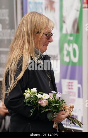 A woman carries flowers as she arrives at the scene near Belfairs Methodist Church in Eastwood Road North, Leigh-on-Sea, Essex, where Conservative MP Sir David Amess died after he was stabbed several times at a constituency surgery on Friday. Picture date: Saturday October 16, 2021. Stock Photo