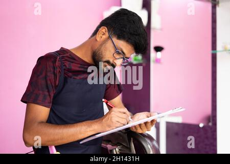 Barber checking financial documents or agreement papers before signing at saloon. Stock Photo