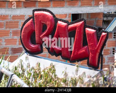 Red Balloon with the Word 'Crazy' in a Garden in Medellin, Colombia Stock Photo