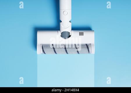 A vacuum cleaner nozzle with a clean stripe on a blue background. Free space Stock Photo