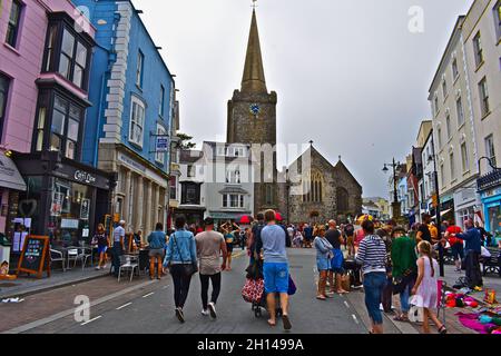 The colourful array of buildings in the town centre with shops cafés and restaurants. The tower and spire of St Mary's church dominates skyline. Stock Photo