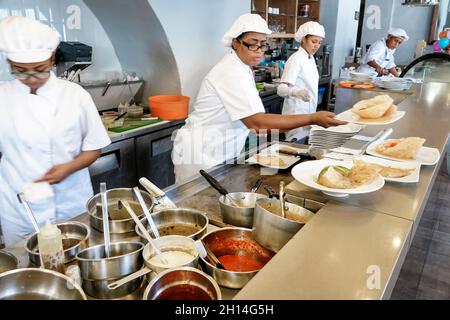 Cartagena Colombia,Crepes & Waffles restaurant,inside interior open kitchen cook chef,Black female women working plating food preparing order Stock Photo