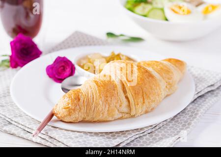 Breakfast oatmeal porridge with boiled egg, cucumber and croissant, jam, coffee. Healthy balanced food. Stock Photo