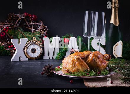 Baked  chicken or turkey. The Christmas table is served with turkey, decorated with bright tinsel. Fried chicken, table. Christmas dinner. Table setti Stock Photo