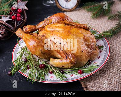 Baked  chicken or turkey. The Christmas table is served with turkey, decorated with bright tinsel. Fried chicken, table. Christmas dinner. Table setti Stock Photo