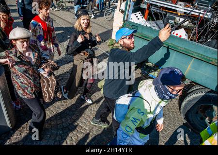 Amsterdam, Netherlands. 16th Oct, 2021. A group of protesters seen dancing behind one of the trucks with a sound system installed during the rally.Thousands of people accompanied by trucks with loud music danced through the center of Amsterdam. ADEV (Amsterdam Danst Ergens Voor) means 'Amsterdam Dances For Somewhere'. Every year, the ADEV demonstrators dance for creative free spaces in the city. This year, also they protest against the housing crisis, because of that the theme was stop the Monopoly game in Amsterdam. Credit: SOPA Images Limited/Alamy Live News Stock Photo