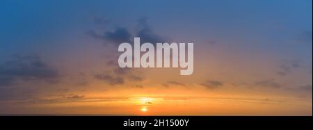 Sunset panorama with blurred colorful sky and orange sun Stock Photo