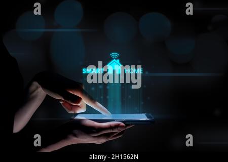 Smart home concept with a hologram over a tablet in the hands of a woman Stock Photo