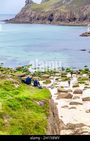 Couple taking a lunch break at Nanjizal Beach along the South West Coast Path, Cornwall, UK Stock Photo