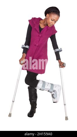 Young African woman with a broken leg wearing a cast and walking with crutches, , isolated on white background Stock Photo