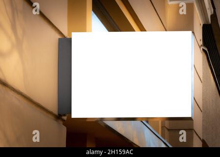 Mock up. Blank white rectangular shape signboard on the wall outdoors. Signage of shop, store, cafe, restaurant Stock Photo