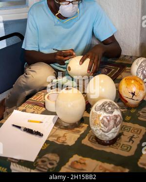 African craftsman carving sculpting few ostrich eggs by hand Stock Photo