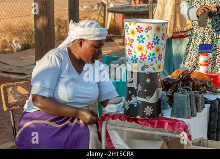 African street vendors, zezuru woman, on the road selling African art Stock Photo