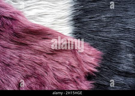 Warming berry-coloured, black and white synthetic fashion furs. Stock Photo