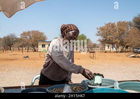 African street vendors on the road selling raw peanuts, corn, monkey oranges and mopane worms, Stock Photo