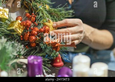 Woman is making homemade advent wreath close up. Horizontally. Stock Photo
