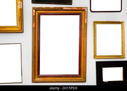 Close-up isolated photo of various empty picture frames hanging on gray wall. Stock Photo