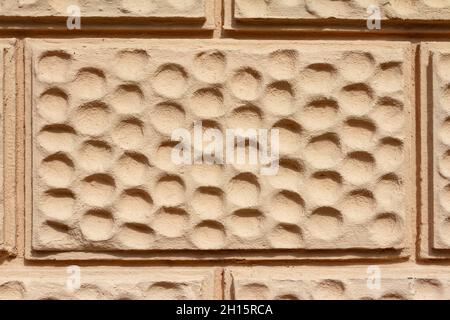 Close-up photo texture of beige painted brick wall surface with circle ornament. Stock Photo