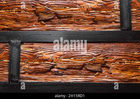 Texture close-up photo of varnished wood logs with metal frame holding it. Stock Photo