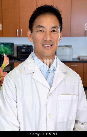 Asian male doctor in his front desk office Stock Photo